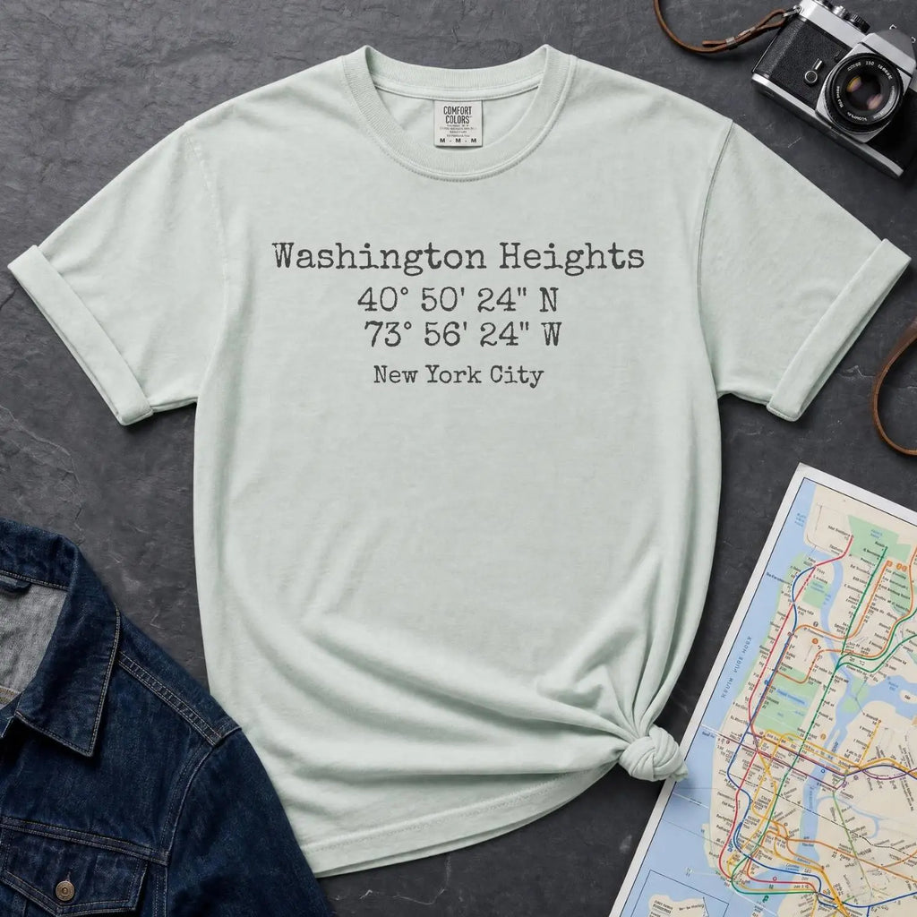 Bay colored Comfort Colors t-shirt with 'Washington Heights' text with coordinates and 'New York City' on a dark surface with a map and denim jacket.