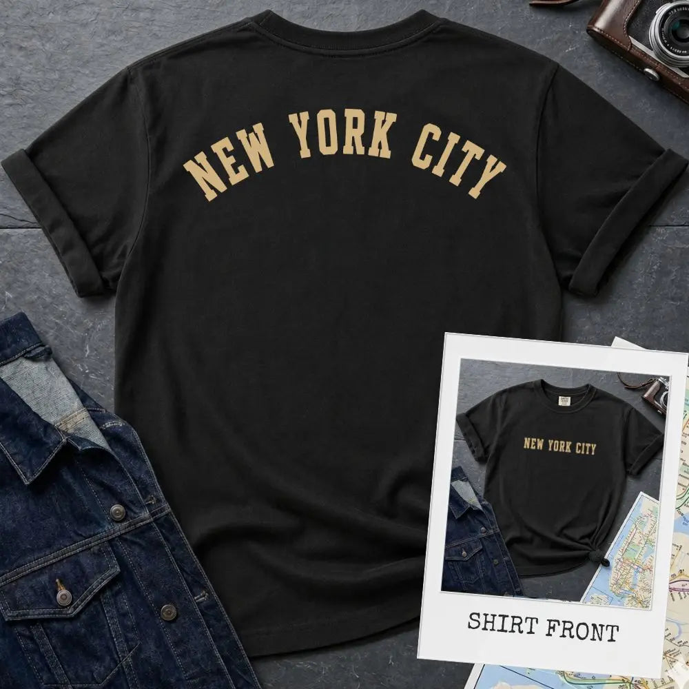 Black Comfort Colors t-shirt with 'New York City' print on a textured surface with a camera and denim jacket.