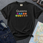 Black Comfort Colors t-shirt featuring a minimalist Queens subway line graphic with colorful NYC train icons.