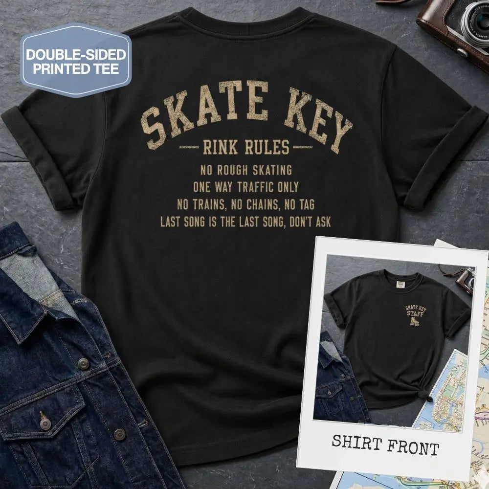 Black Comfort Colors t-shirt, back view, with Skate Key Rink Rules printed in distressed gold lettering. Rules read: No Rough Skating, One Way Traffic Only, No Trains No Chains No Tag, Last Song Is The Last Song Don't Ask. Inset shows shirt front with Skate Key Staff logo on chest.