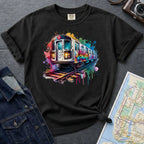 Black Comfort Colors t-shirt with a colorful graffiti NYC subway train graphic on a gray surface with a map and jacket.