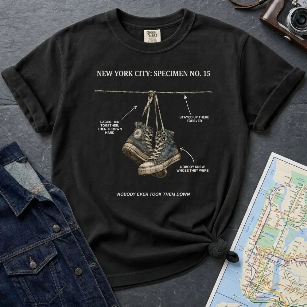 Black Comfort Colors T-shirt with NYC sneakers on wire specimen front print, styled with denim jacket, camera, and subway map