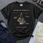 Black Comfort Colors T-shirt with NYC sneakers on wire specimen front print, styled with denim jacket, camera, and subway map