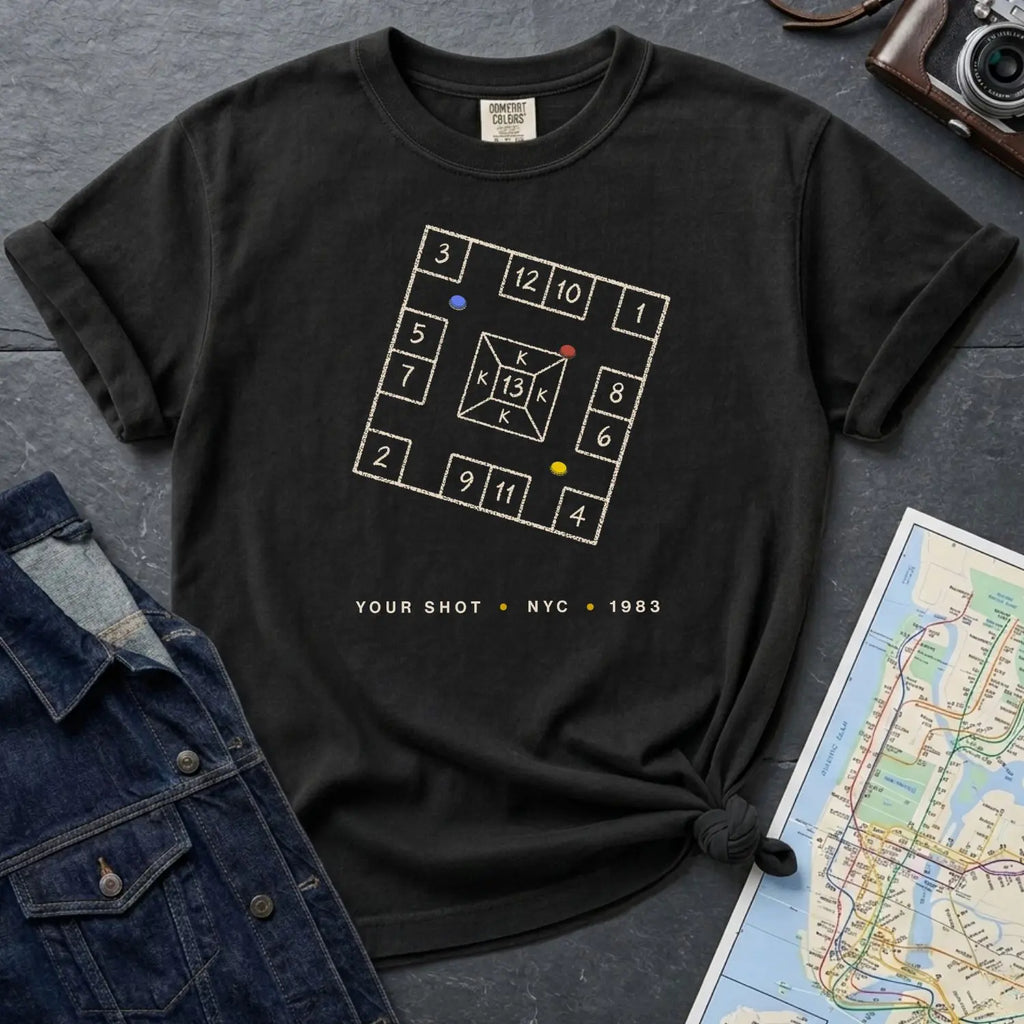 Black Comfort Colors t-shirt with New York City skelzies design on a gray surface with denim jacket and map.