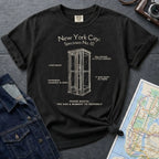 Black Comfort Colors t-shirt with phone booth design and text on a dark surface with denim jacket and map.