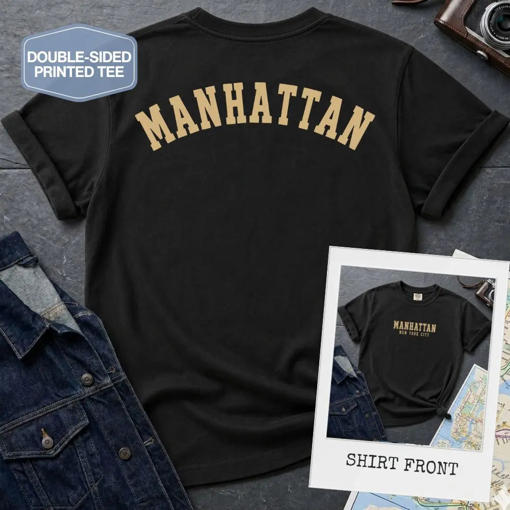 Black Comfort Colors t-shirt with 'MANHATTAN' printed on it, displayed with a denim jacket and map in the background.