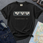 Black Comfort Colors t-shirt with NYC Transit Authority design on a dark surface with a map and a denim jacket.