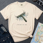 Ivory Comfort Colors t-shirt with graphic design of a squeegee and text, placed on a dark surface with a denim jacket and a map.
