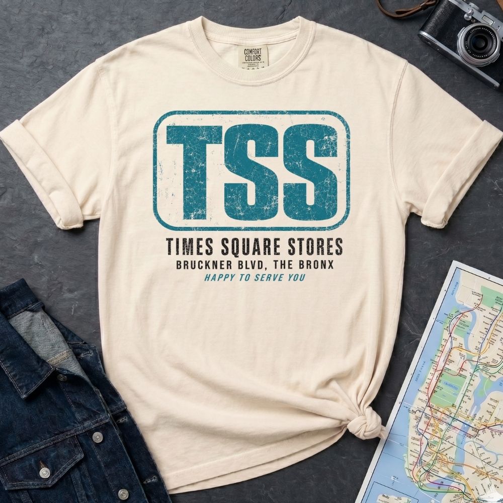 Ivory Comfort Colors T-shirt with blue TSS Times Square Stores Bronx front print, styled with denim jacket, camera, and subway map