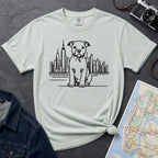 Bay colored t-shirt with a Pitbull dog and cityscape design on a dark surface with jeans and a map.