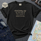 Black Comfort Colors t-shirt with coordinates and text 'chelsea, ny' and 'where we met' on a dark surface with denim jacket and map.