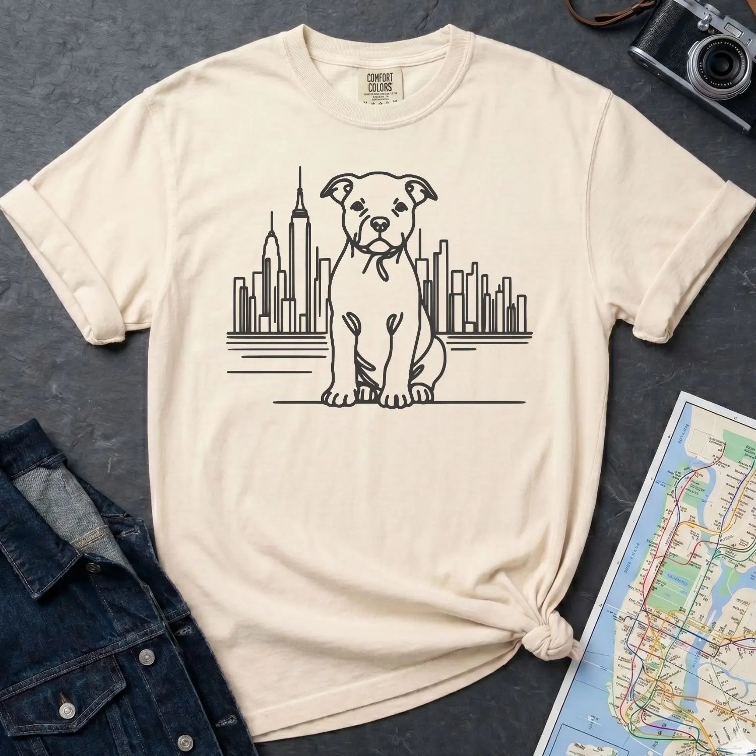 Ivory Comfort Colors t-shirt with a Pitbull dog and cityscape design on a gray surface with a denim jacket and map.