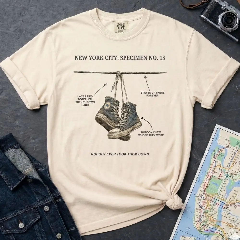 Ivory Comfort Colors T-shirt with NYC sneakers on wire specimen front print, styled with denim jacket, camera, and subway map