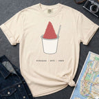 Ivory Comfort Colors t-shirt with a piragua graphic and text, placed on a dark surface with a map and denim jacket.