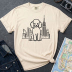 Ivory Comfort Colors t-shirt with a Poodle and cityscape design on a dark surface with a denim jacket and a map.