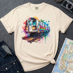 Ivory Comfort Colors t-shirt with a colorful graffiti NYC subway train graphic on a dark surface with a denim jacket and a map.
