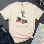Ivory Comfort Colors t-shirt featuring a vintage roller skate graphic with “Roll With It • NYC • 1988” text on a dark surface with a denim jacket and map.