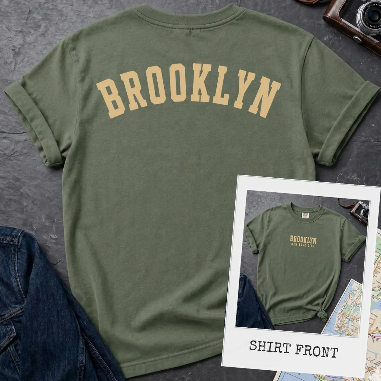 Moss green colored Comfort Colors t-shirt with 'Brooklyn' printed on the back and 'Brooklyn, New York City', on a dark surface. 