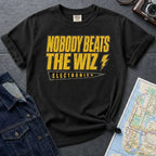 Black Comfort Colors T-shirt with yellow and black The Wiz Electronics NYC front print, styled with denim jacket, camera, and subway map