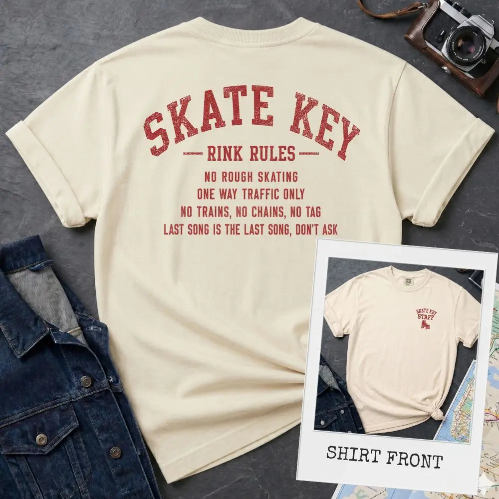 Ivory Comfort Colors t-shirt, back view, with Skate Key Rink Rules printed in distressed red lettering. Rules read: No Rough Skating, One Way Traffic Only, No Trains No Chains No Tag, Last Song Is The Last Song Don't Ask. Inset shows shirt front with Skate Key Staff logo on chest.