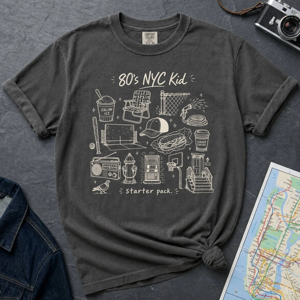 Pepper colored Comfort Colors t-shirt with an 80’s NYC Kid starter pack graphic featuring Italian ice, stickball, a fire hydrant, corner coffee, and stoop illustrations.