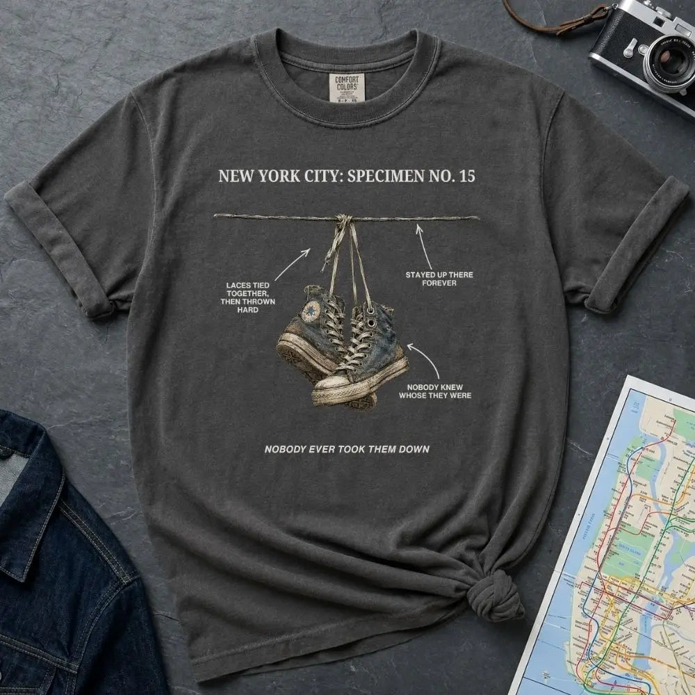 Pepper colored Comfort Colors T-shirt with NYC sneakers on wire specimen front print, styled with denim jacket, camera, and subway map