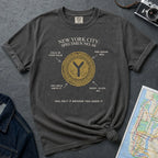 Pepper colored Comfort Colors t-shirt with New York City vintage token design on a gray surface with denim jacket and map.