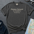 Pepper colored Comfort Colors t-shirt with Staten Island text and coordinates on a dark surface with denim jacket and map.
