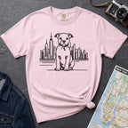 Pink t-shirt with a Pitbull dog and cityscape design on a dark surface with jeans and a map.