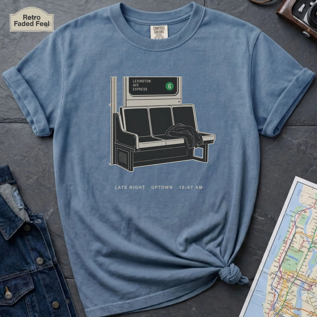 Blue Jean colored t-shirt with a graphic design of a train interior and text on a dark surface.