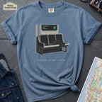 Blue Jean colored t-shirt with a graphic design of a train interior and text on a dark surface.