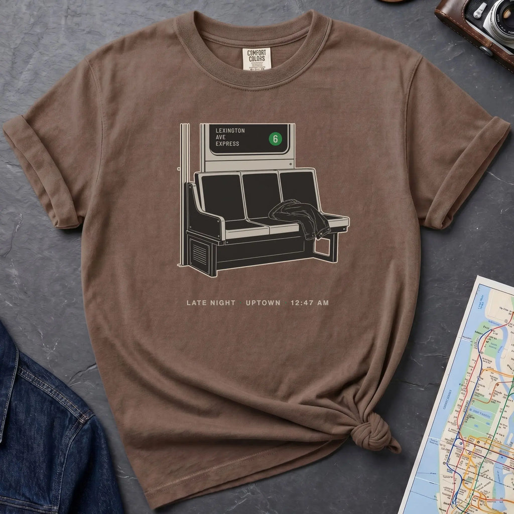 Espresso colored t-shirt with a graphic design of a train interior and text on a dark surface.