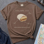 Brown t-shirt with a graphic of a bodega sandwich and text on a gray surface with a map.