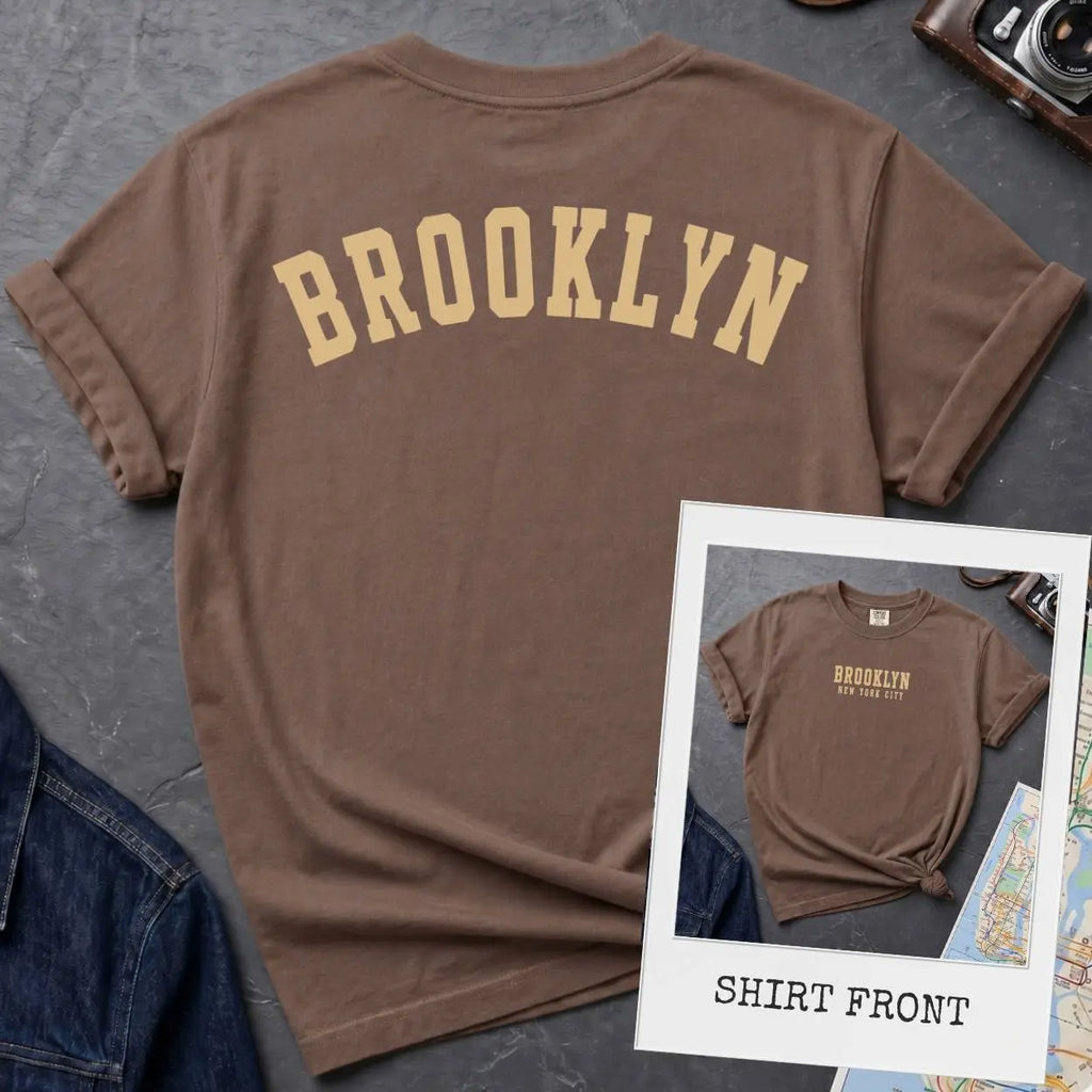 Espresso colored Comfort Colors t-shirt with 'Brooklyn' printed on the back and 'Brooklyn, New York City', on a dark surface. 