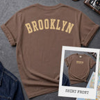 Espresso colored Comfort Colors t-shirt with 'Brooklyn' printed on the back and 'Brooklyn, New York City', on a dark surface. 
