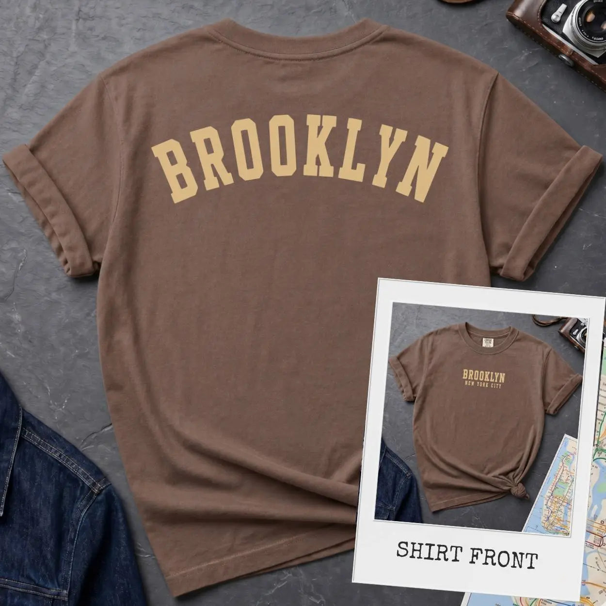 Espresso colored Comfort Colors t-shirt with 'Brooklyn' printed on the back and 'Brooklyn, New York City', on a dark surface. 