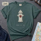 Blue Spruce t-shirt with a fire hydrant graphic on a dark surface with a map and jeans.