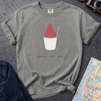 Gray Comfort Colors t-shirt with a piragua graphic and text, placed on a dark surface with a map and denim jacket.