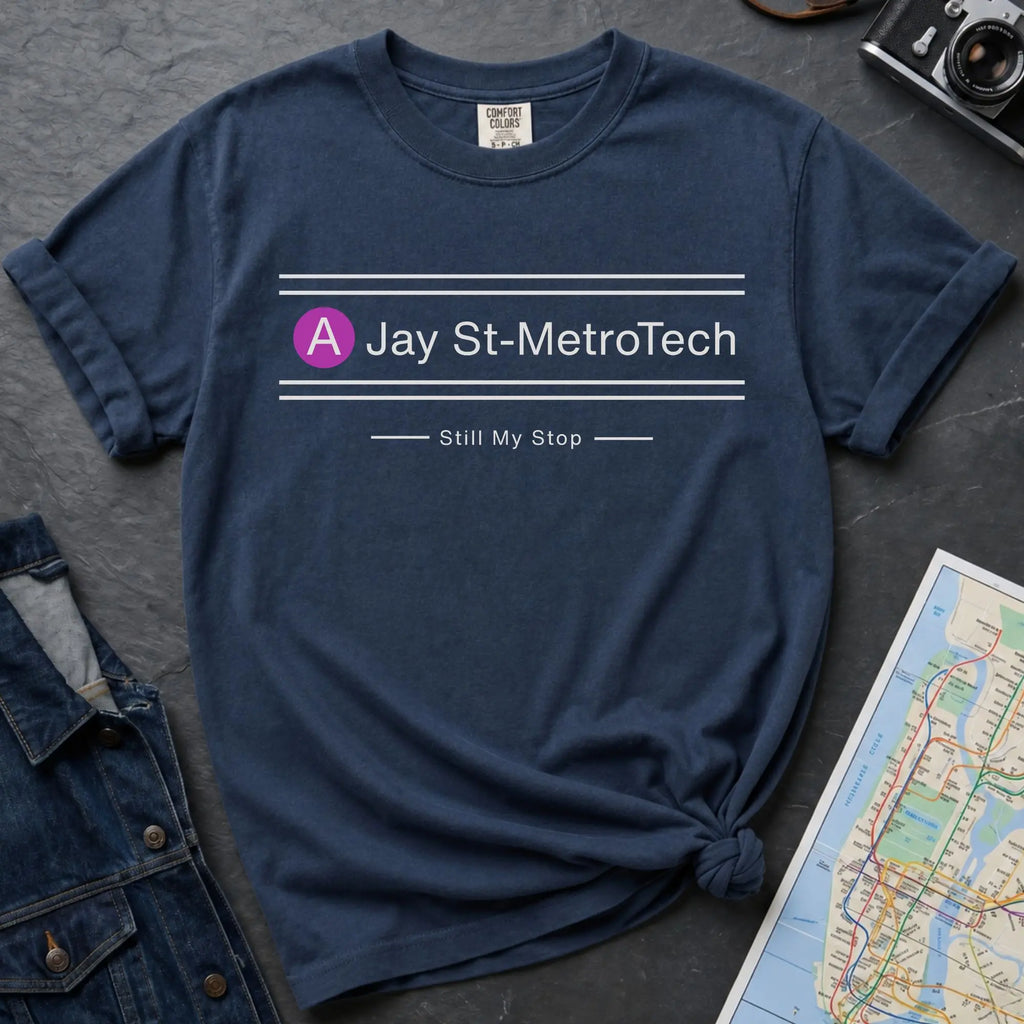 Navy blue t-shirt with 'Jay St-MetroTech' design on a dark surface with a map and denim jacket.