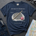 Navy Comfort Colors t-shirt with a stickball graphic and text on a dark surface with denim jacket and map.