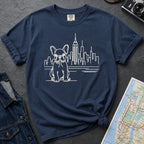 Navy t-shirt with a French Bulldog and cityscape design on a gray surface with a denim jacket and a map.