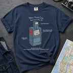 Navy t-shirt with a newspaper box graphic and text on a textured surface with a camera and map.