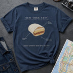 Navy blue t-shirt with a graphic of a bodega sandwich and text on a gray surface with a map and denim jacket.