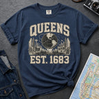 Navy t-shirt with 'Queens Est. 1683' graphic design on a dark surface with a denim jacket and a map.