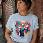 Person wearing a light blue t-shirt with a colorful graphic of a person spray painting a mural.