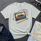 Bay colored t-shirt with a cassette tape graphic and pencil on a gray surface with a map and denim jacket.