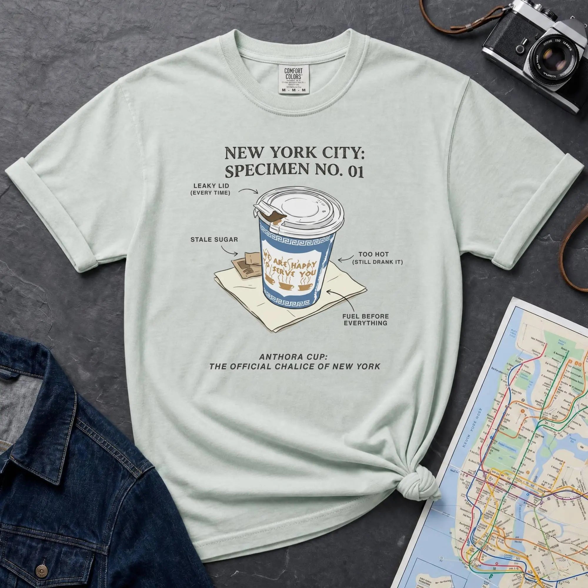 Bay colored Comfort Colors t-shirt featuring a vintage New York City Anthora coffee cup graphic with specimen-style callouts and “The Official Chalice of New York” text.