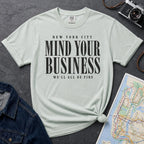 Bay colored Comfort Colors t-shirt featuring bold New York City “Mind Your Business, We’ll All Be Fine” text in a vintage black typography design.