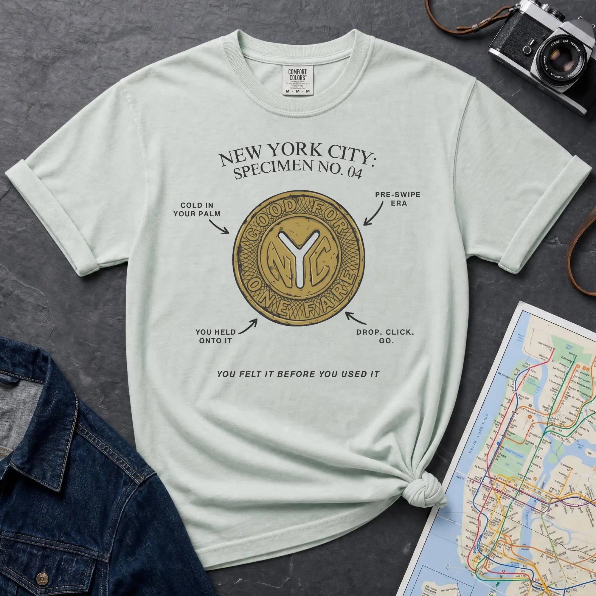 Bay colored Comfort Colors t-shirt featuring a vintage New York City subway token graphic with specimen-style callouts and “You felt it before you used it” text.
