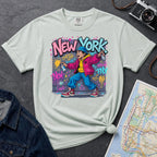 Bay colored Comfort Colors t-shirt featuring a colorful NYC graffiti-style New York graphic with a young street artist holding a spray paint can